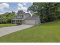 Two-story home with a well-manicured lawn, long driveway, and attached two-car garage at 5515 Pennybrook Trl, Stone Mountain, GA 30087