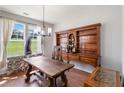 Dining room showcasing a rustic wooden table, antique buffet, and natural light from a window at 5351 Paramount View Way, Sugar Hill, GA 30518