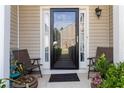 Inviting front porch with chairs, planters, and a welcome mat leading to the front door with sidelights at 5351 Paramount View Way, Sugar Hill, GA 30518
