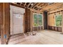 Unfinished living room with exposed wood framing and newly installed windows ready for renovation at 1406 Allene Sw Ave, Atlanta, GA 30310