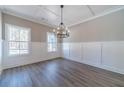 Bright dining room showcasing wood-look floors, wainscotting, and ample natural light from large windows at 1500 Alcovy Station Rd, Covington, GA 30014