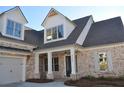 Beautiful brick home featuring a side-entry garage, covered porch, and classic design at 1670 Knob Creek Nw Ct, Acworth, GA 30101