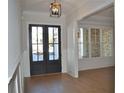 Inviting foyer with hardwood floors, decorative trim, and glass-paneled double doors at 1670 Knob Creek Nw Ct, Acworth, GA 30101