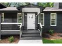 Welcoming front porch with classic white trim and a decorative front door at 1690 Eaglecreek Trl, Cumming, GA 30041