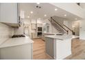 Open-concept kitchen featuring granite countertops, stainless appliances, and hardwood floors at 401 Wellwood Way, Roswell, GA 30075