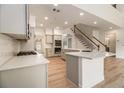 Spacious kitchen featuring a large island, stainless steel appliances and staircase to the upper level at 401 Wellwood Way, Roswell, GA 30075