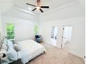 Bright main bedroom featuring a tray ceiling, neutral carpet, and ensuite bathroom and walk-in closet entrances at 195 Burbank Nw Dr, Atlanta, GA 30314