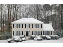Charming two-story home covered in a blanket of snow, accented by classic black shutters at 2903 Brookshire Way, Duluth, GA 30096