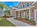 Charming home featuring brick, stone accents, manicured landscaping and a sidewalk leading to a covered front porch at 1114 Low Water Crossing Nw, Acworth, GA 30101