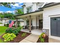 Inviting covered front porch with seating area, an American flag, and well manicured landscaping at 1442 Pierce Se Ave, Smyrna, GA 30080