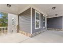 Inviting covered porch with stone accents and neutral siding showcases outdoor living space at 3198 Garden Hill Ln, Douglasville, GA 30135