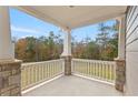 Cozy covered porch features stone columns and a serene view of the landscaped backyard at 3198 Garden Hill Ln, Douglasville, GA 30135