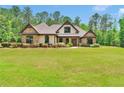Lovely single-Gathering home surrounded by lush landscaping and sprawling green lawn on a sunny day at 35 Cornish Creek Ln, Covington, GA 30014