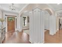 Elegant foyer with hardwood floors, decorative columns, and a wooden front door at 35 Cornish Creek Ln, Covington, GA 30014