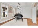 Bright living room featuring a piano, hardwood flooring, and large windows at 35 Cornish Creek Ln, Covington, GA 30014