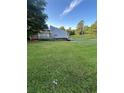 View of the side and rear of a home featuring well-maintained green lawn and ample space for parking at 102 Bascomb Drive Dr, Woodstock, GA 30189