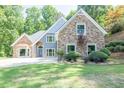 Charming home with stone and blue siding, complemented by a well-manicured lawn and landscaped hillside at 3365 Sweetwater Dr, Cumming, GA 30041