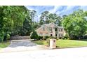 Well-maintained home with a driveway, lush lawn, mature trees, and beautiful stone details at 4335 Burgomeister Pl, Snellville, GA 30039