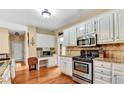 Bright kitchen featuring stainless steel appliances, granite countertops and white cabinets at 4335 Burgomeister Pl, Snellville, GA 30039