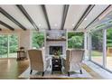 Cozy living room with a fireplace, beamed ceilings, and large windows overlooking the backyard at 687 Monticello Se Way, Marietta, GA 30067
