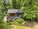 Aerial view of cozy home with wooded landscaping, a dark exterior, and a well-maintained front yard at 2468 Fallview Ter, Atlanta, GA 30344