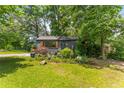 Charming home featuring a dark gray exterior, well-manicured landscaping, and eye-catching wooden window shutters at 2468 Fallview Ter, Atlanta, GA 30344