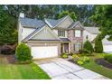 Charming two-story home featuring brick and stone accents, a well-manicured lawn, and a two-car garage at 58 Lilyfield Ln, Acworth, GA 30101