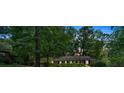 Traditional single-story brick home nestled among mature trees and greenery at twilight at 1618 Mason Mill Ne Rd, Atlanta, GA 30329