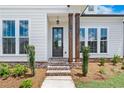 Inviting front porch with stylish dark wood columns and lush landscaping enhancing curb appeal at 513 Godfrey Dr, Cumming, GA 30040