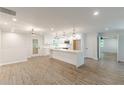 Open floor plan kitchen with island, white cabinetry, stainless appliances, and wood flooring at 2806 Hedgewood Nw Dr, Atlanta, GA 30311