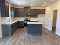 Well-lit kitchen features stainless steel appliances, a center island, and plentiful cabinet space at 777 Oakmont Trce, Canton, GA 30114