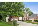 Beautifully landscaped two-story brick home with a charming entryway and well-maintained lawn at 130 White Sands Ct, Suwanee, GA 30024