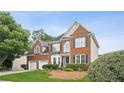 Charming brick home with blue shutters, lush landscaping, and a well-manicured lawn at 130 White Sands Ct, Suwanee, GA 30024