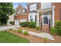 Inviting front entrance with a charming walkway, landscaped garden beds, and two car garage at 130 White Sands Ct, Suwanee, GA 30024