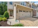 Attractive brick townhome featuring a spacious two-car garage and a welcoming front entrance at 490 Duval Dr, Alpharetta, GA 30009