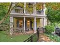 Inviting home with a covered front porch featuring decorative columns, a small garden, and a well-maintained lawn at 635 Holcomb Bridge Rd, Norcross, GA 30071