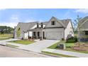 Attractive single-Gathering home featuring a concrete driveway, lush lawn, and stone-accented front porch columns at 1649 Tielman Way, Snellville, GA 30078