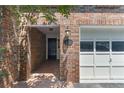 Inviting entryway with a brick facade, well-lit porch, and garage access at 433 The North Chace, Atlanta, GA 30328