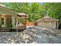 Large driveway leads to a detached two-car garage, next to pergola and outdoor seating at 1042 Bailey Rd, Woodstock, GA 30188
