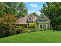 Beautiful single-Gathering home featuring a well-manicured lawn, mature trees, and cozy curb appeal at 1042 Bailey Rd, Woodstock, GA 30188
