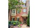 Inviting brick townhouse with lush landscaping and colorful flowers enhancing its curb appeal at 578 Parkside Village Nw Way, Marietta, GA 30060