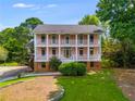 Two-story pink home with double front porches, white columns, and expansive lawn at 3348 Summit Turf Ln, Snellville, GA 30078