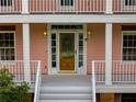 Close-up of a wood front door with sidelights and two-story white columned porch at 3348 Summit Turf Ln, Snellville, GA 30078