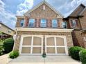 Charming brick townhome featuring a two-car garage and well-maintained landscaping at 3534 Clancy Way, Smyrna, GA 30080