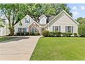 Traditional home with a well-maintained lawn, shutters, stone accents, and a driveway at 4042 Laurel Bend Ct, Snellville, GA 30039