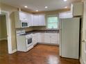 Well-lit kitchen with white cabinets, appliances, and hardwood floors at 410 S Gordon Sw Rd, Mableton, GA 30126