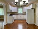 Well-lit kitchen with white cabinets, appliances, and hardwood floors at 410 S Gordon Sw Rd, Mableton, GA 30126