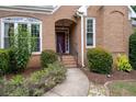 Inviting entrance with a brick walkway, garden, and arched porch leading to a solid front door at 10880 Windham Way, Alpharetta, GA 30022