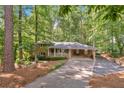 Charming brick home with covered porch, carport, and beautifully landscaped front yard with mature trees at 620 Amberidge Trl, Atlanta, GA 30328