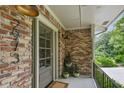 Inviting front porch with brick detail, stylish lighting, and a view of the surrounding greenery at 2973 Payton Ne Rd, Atlanta, GA 30345